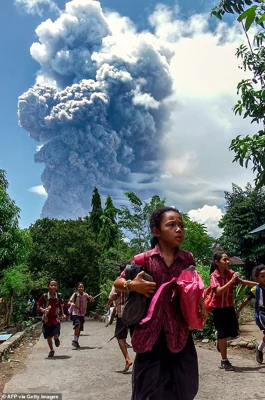 School children were seen running from Mount Lewotobi Laki-Laki in Indonesia when it first erupted (pictured)