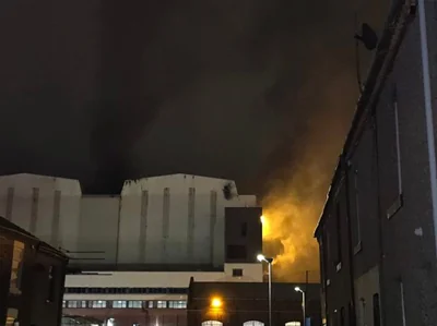 Fierce orange flames can be seen at the side of the building