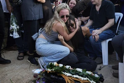 Israelis mourn next to the grave of Maya Puder, 25, during her funeral in Zikhron Ya'akov northern Israel, October 12, 2023