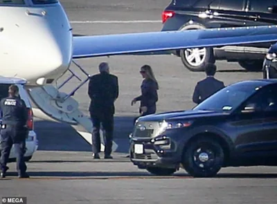 Secret Service agents are seen here as the ex First Lady made her way onto a private plane in New York on Sunday