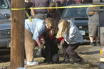 People are comforted near Sandy Hook Elementary School on December 14, 2012 in Newtown