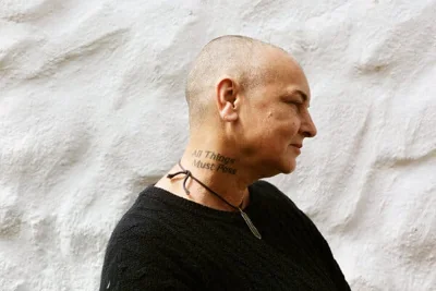 A portrait of Sinead O’Connor. A tattoo on her neck says “All Things Must Pass.”