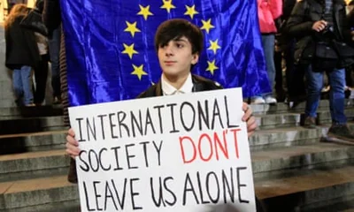 A man holds a poster during an opposition protest against the results of the parliamentary election in Tbilisi, Georgia.