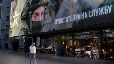 Ілюстративне фото. Чоловік проходить повз екран із закликом про контракт на службу в збройних силах рф у центрі Москви, 28 вересня 2023 року