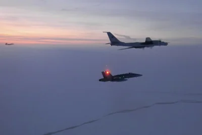 In this photo released by NORAD, a Russian Tu-142 maritime reconnaissance aircraft, top, is intercepted near Alaska, March 9, 2020.