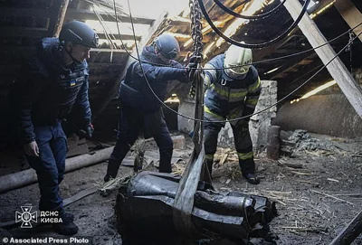 In this photo provided by the Ukrainian Emergency Service, emergency services personnel remove part of a Russian missile that hit an apartment house during massive missile attack in Kyiv, Ukraine, this past weekend, on Sunday, Nov. 17, 2024