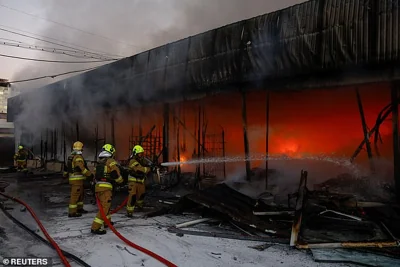 Firefighters work at a compound of a vegetable warehouse hit by a Russian drone strike