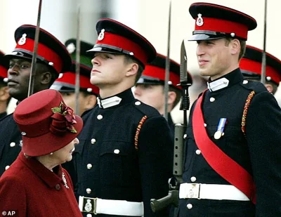 Britain's Queen Elizabeth II and her grandson Prince William, right, exchange smiles, as she inspects graduates during the Sovereign's parade at the Royal Military Academy Sandhurst, December 2006