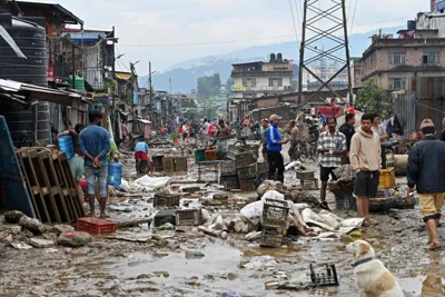 MUD AND DEBRIS Residents clean mud outside their houses in a flood-affected area following heavy monsoon rains in Kathmandu on Sept. 29, 2024. AFP PHOTO