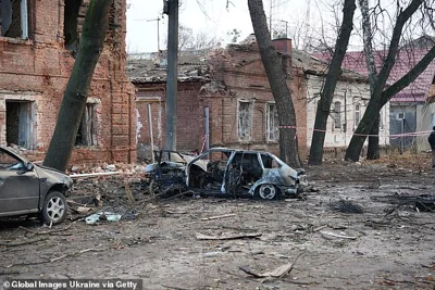 Burnt cars lie near a apartment building damaged by a Russian drone's strike on November 22