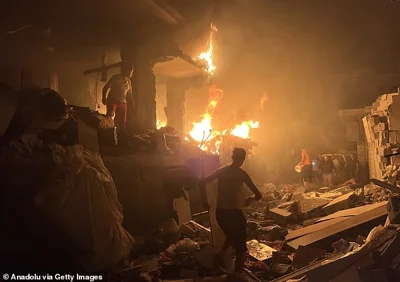 Civil defense teams and Palestinian residents extinguish the fire and search and rescue work in the home of Al-Salhi family after Israeli attacks on Nuseirat refugee camp in Gaza City, Gaza on October 15, 2024