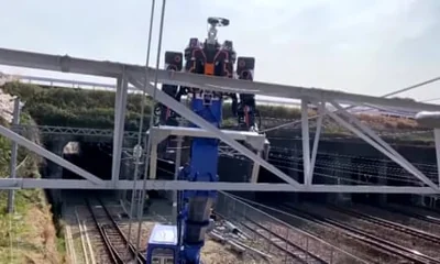 The robot on a metal frame above railway tracks