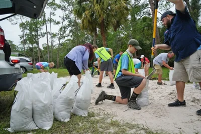 A Park Ranger directs traffic as Pinellas County residents arrive to fill sandbags at John Chestnut Park in Palm Harbor, Fla., on Oct. 6, 2024.