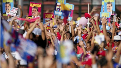 Supporters display posters of President Nicolas Maduro during his closing election campaign rally in Caracas, Venezuela, Thursday, July 25, 2024. 