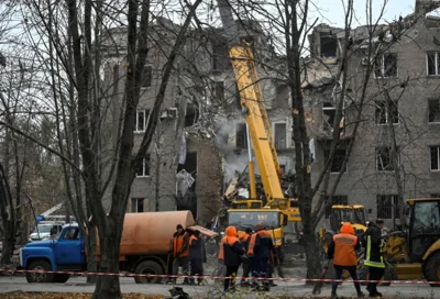 Rescuers and municipal employees work at the site of an apartment building hit by a Russian missile strike,